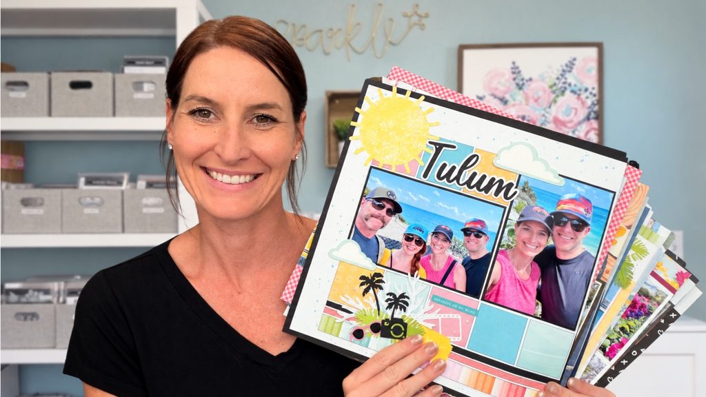 Jayma Malme holding a scrapbook layout in her craft room